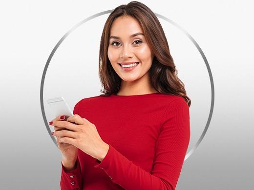 Smiling young woman in red longsleeve holding her phone